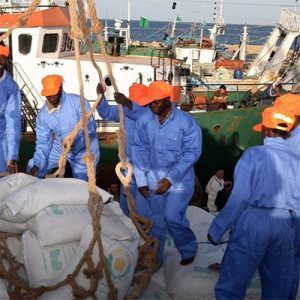Worker in high-visibility conti suit wearing reflective bands on a construction site